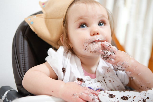 close up of baby smashing cake