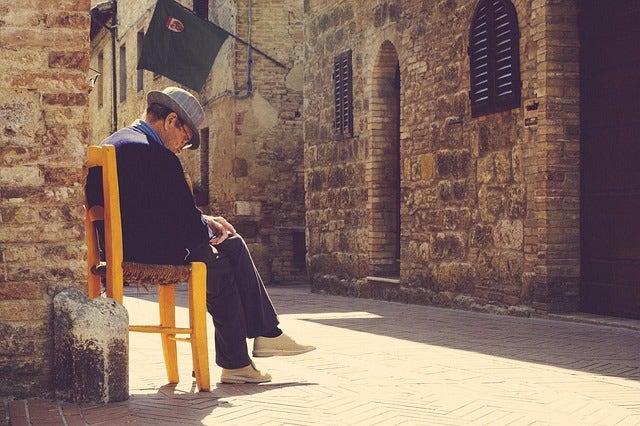 old man falling asleep on chair