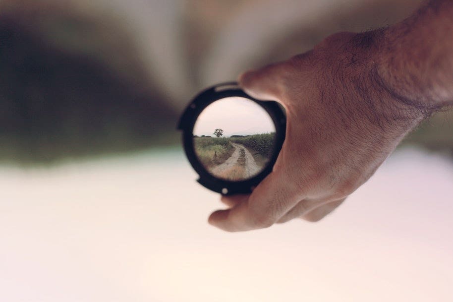 person holding filter with focus on road