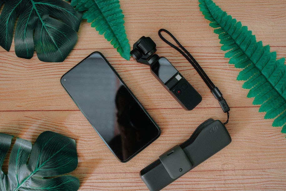 A smartphone laid out on a table with a tripod and gimbal