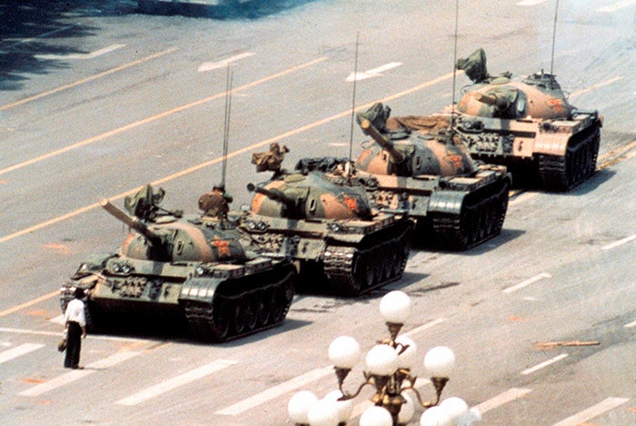 man-stands-in-front-of-line-of-tanks