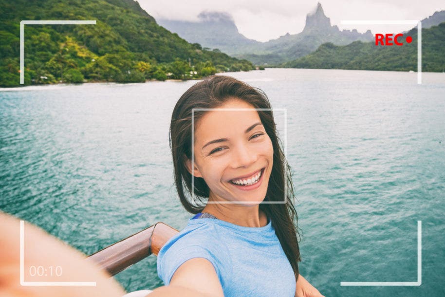 female videographer recording video from boat