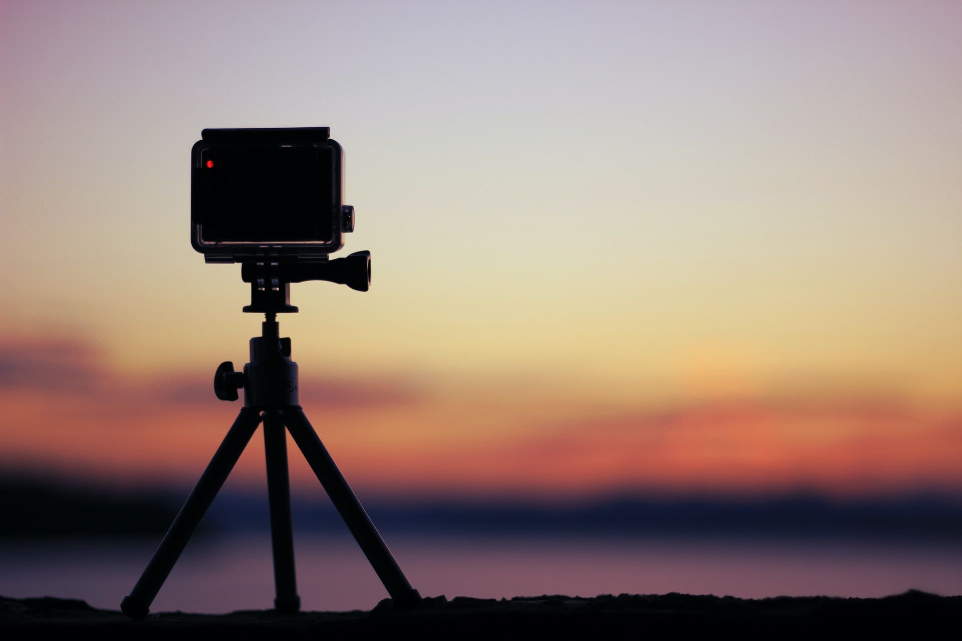 A camera on a mini tripod overlooking sunset