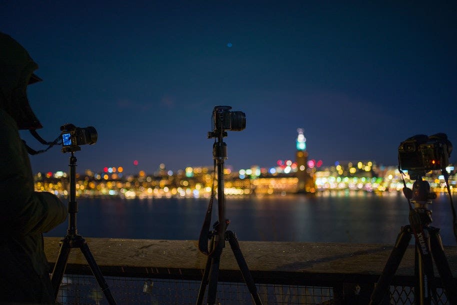 cameras on tripods shooting city night scene