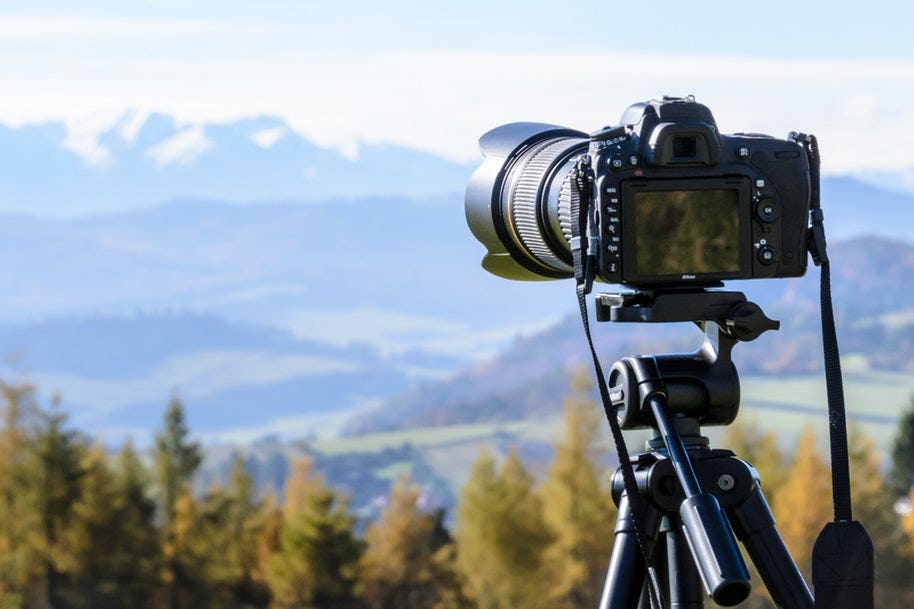 camera and tripod on hilltop