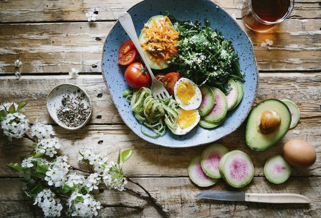 salad in a bowl surrounded by ingredients