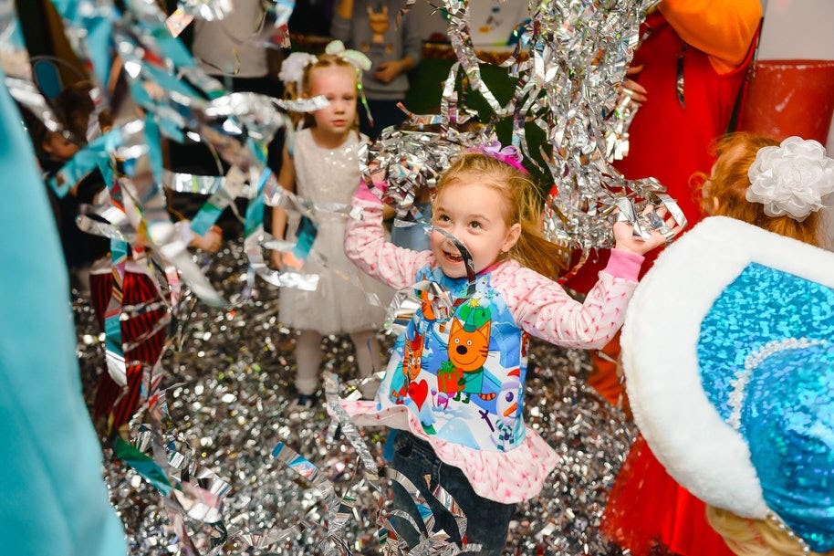 girl at birthday party playing with streamers