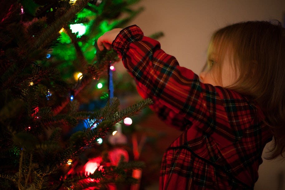 A girl decorating a Christmas tree