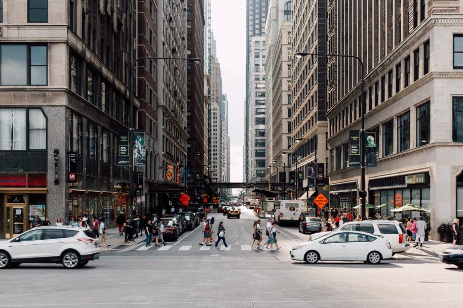 people crossing pedestrian crossing in city on cloudy day