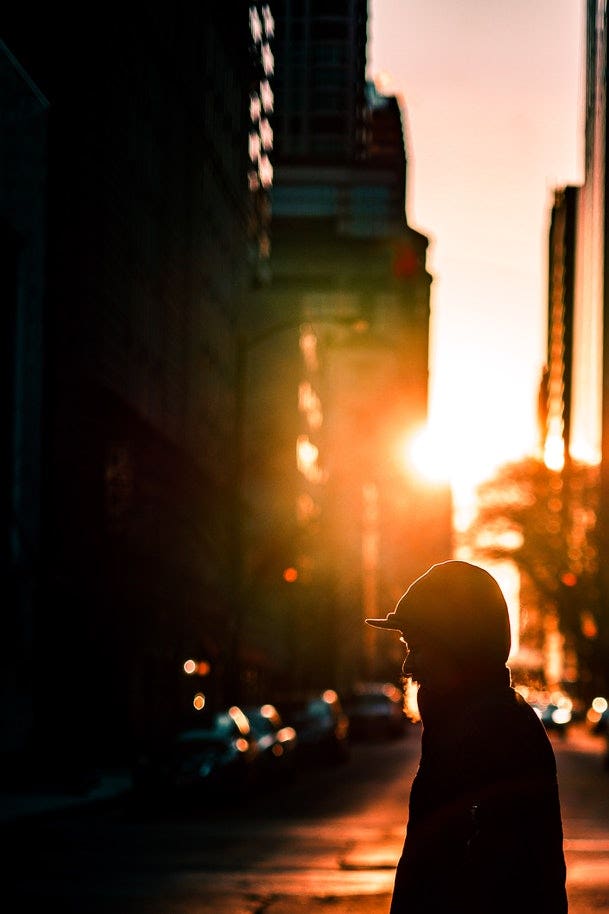 person crossing a street at dawn