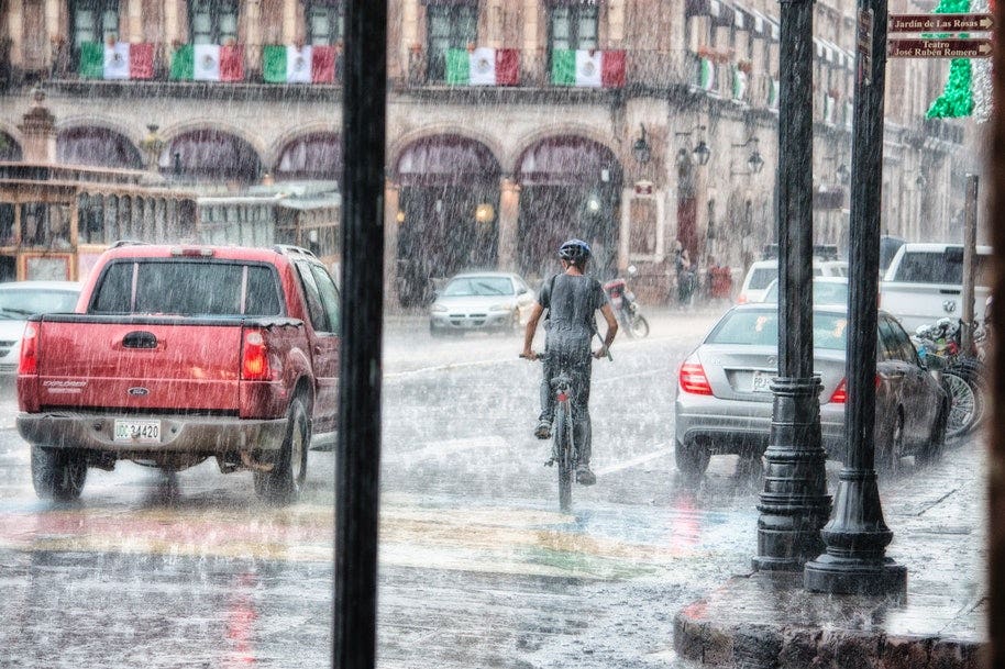 person riding bike in rain