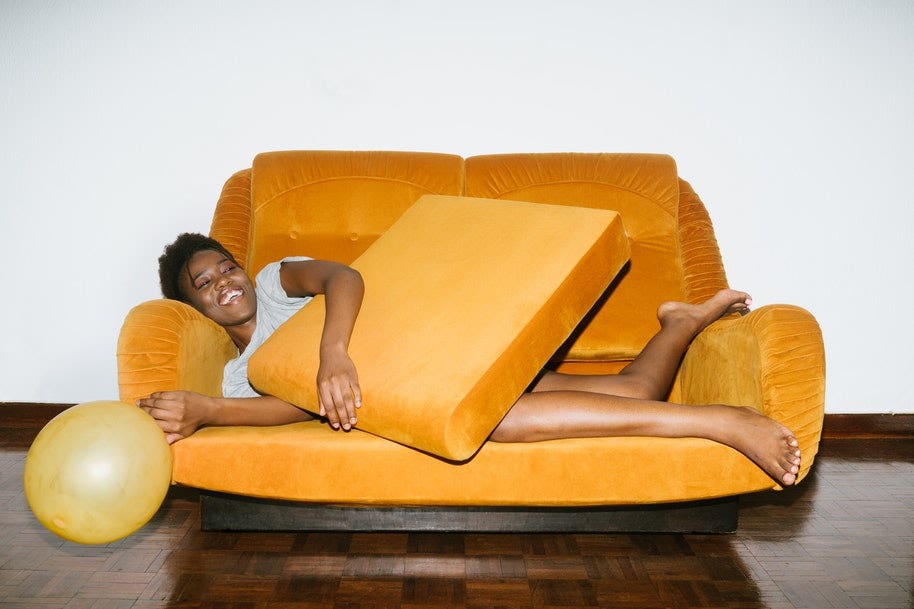 woman lying on orange sofa