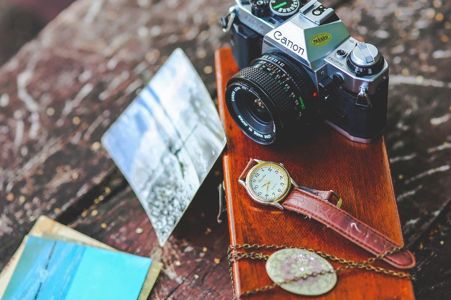 Old Canon camera with clock, necklace and other accessories