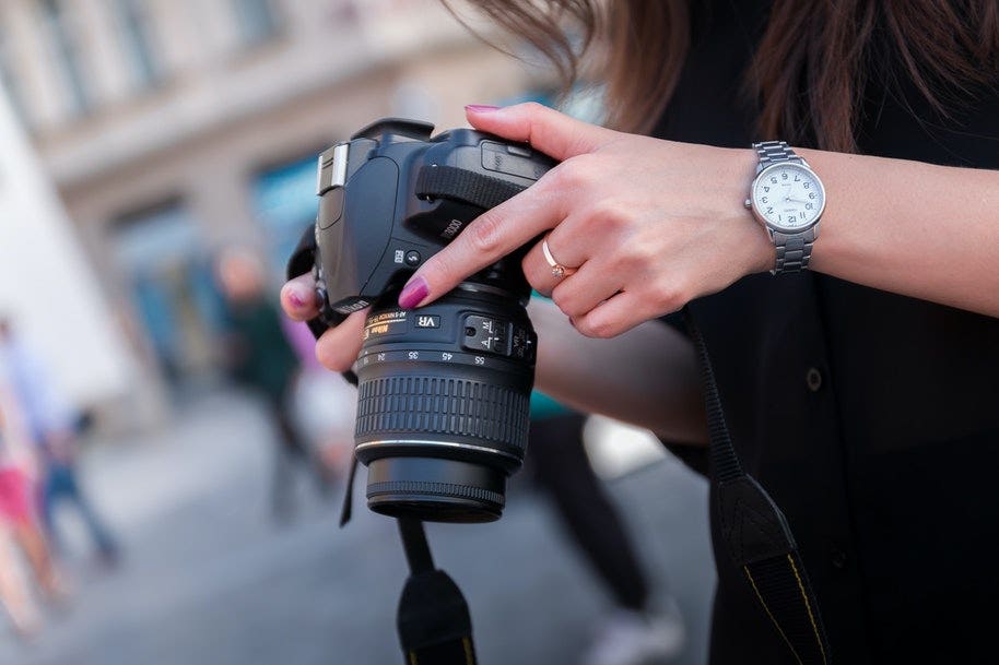 woman holding DSLR camera