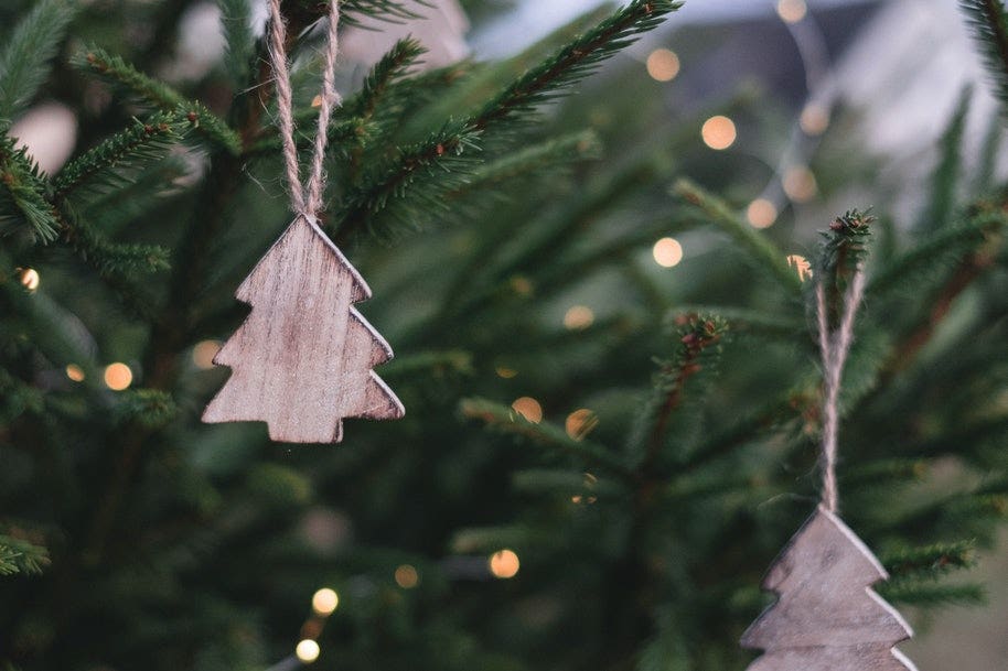 A wooden Christmas tree ornament on a Christmas tree.