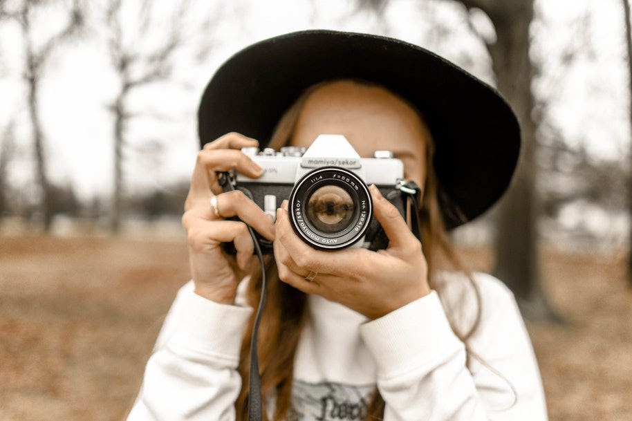 Woman adjusting the focus lens on a camera